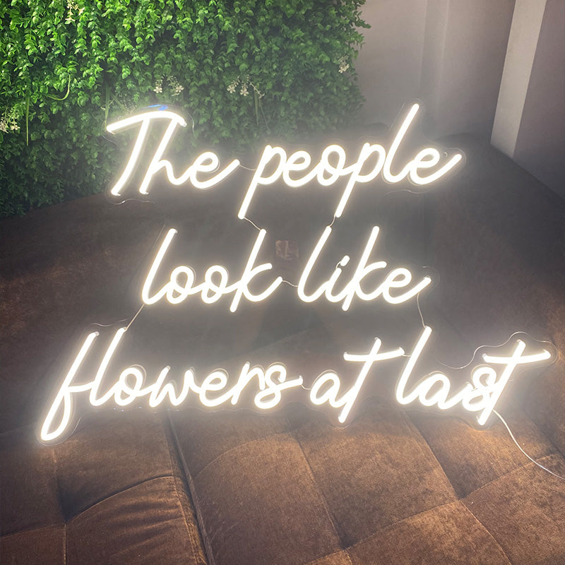 The people look like flowers at last neon sign